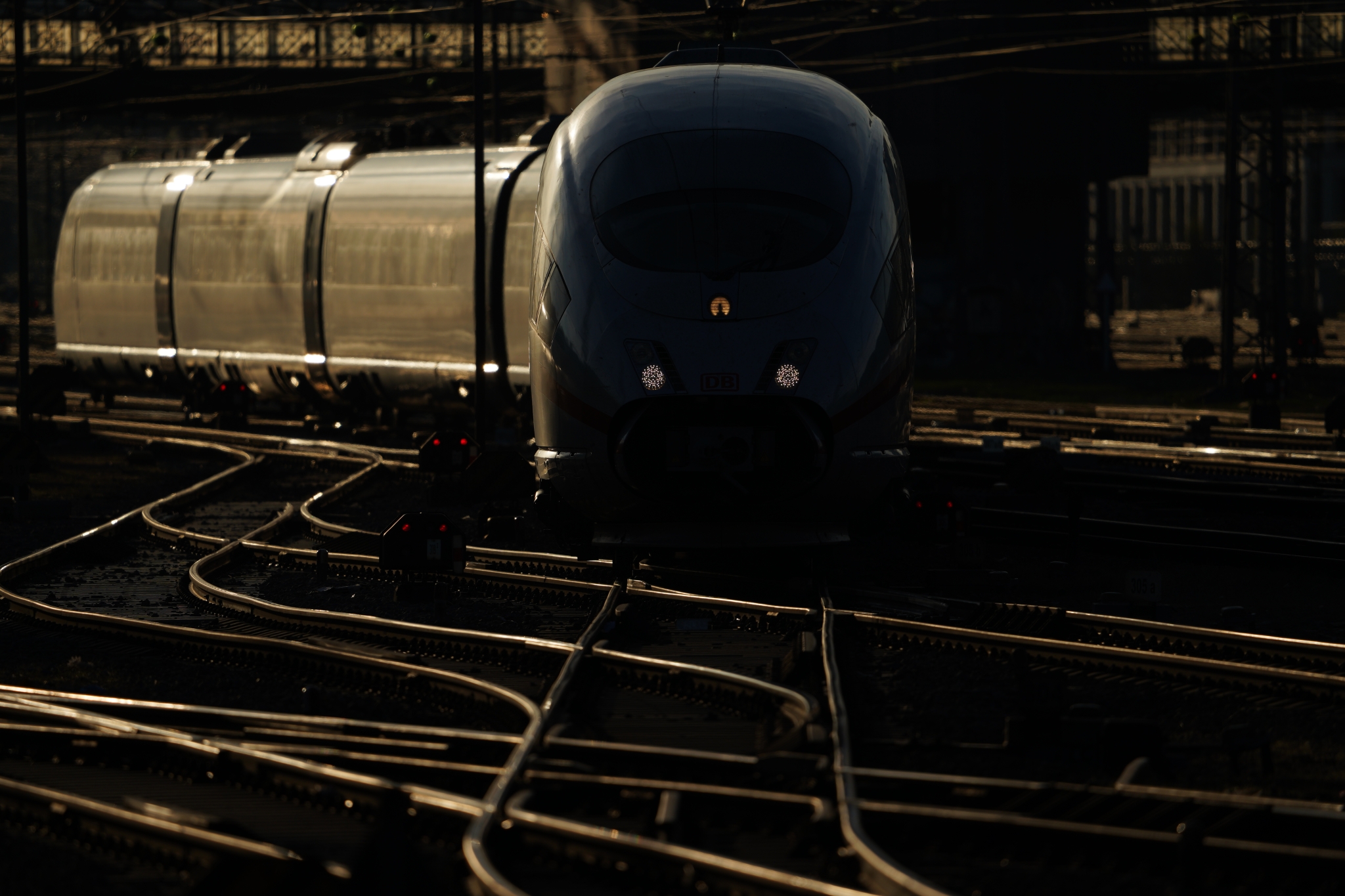 A train on tracks, partially in shadow