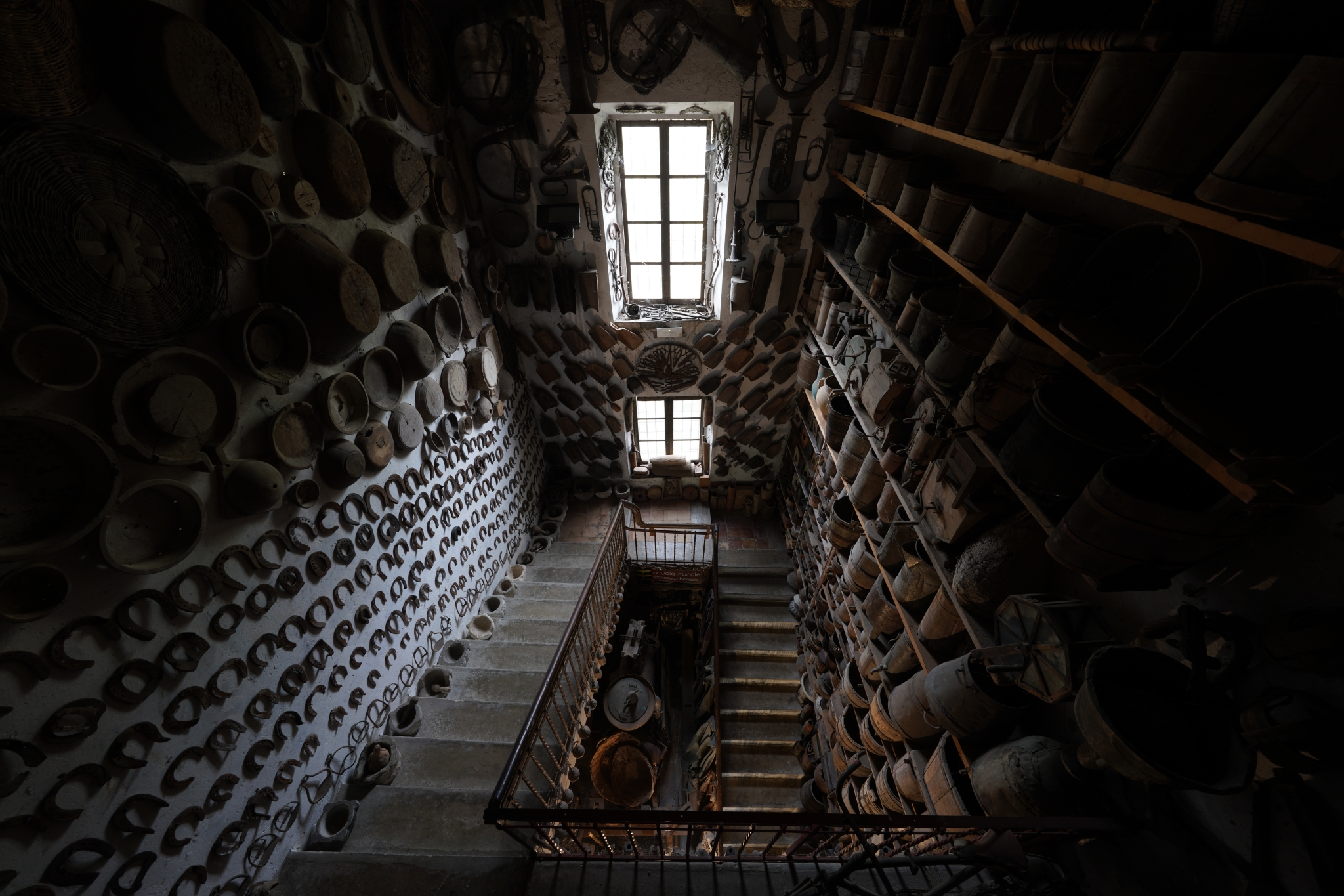 Central staircase inside a storage space for metalworks, barrels and tools