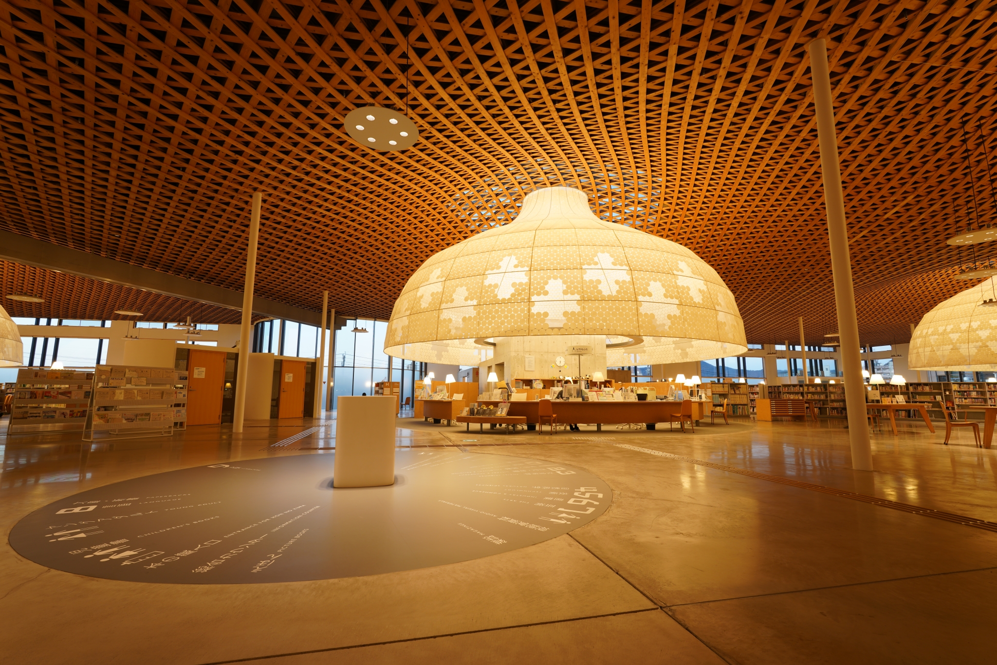 Large atrium with lit seating areas and intricate lattice wood ceiling