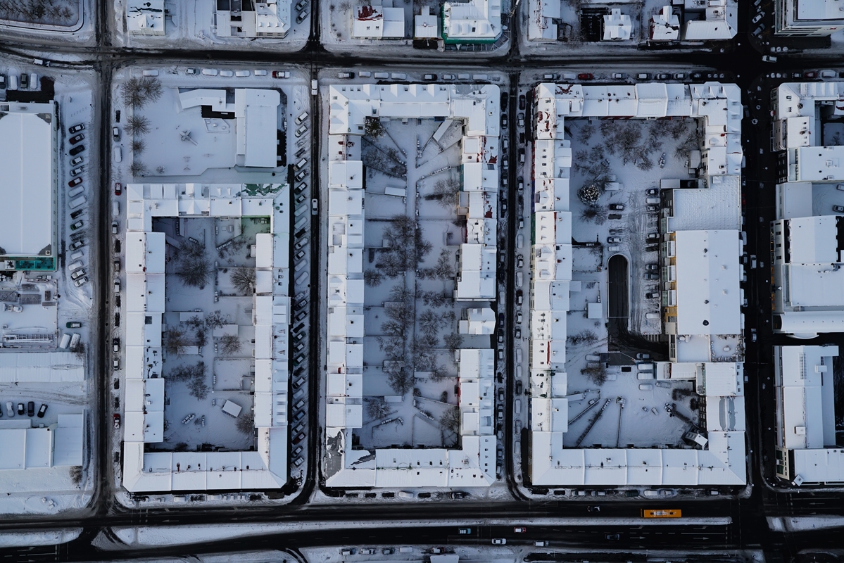 Aerial view looking down on several block-sized buildings with internal courtyards