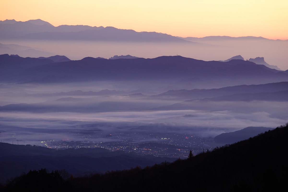 Long and wide shot of post-sunset landscape with low wispy clouds