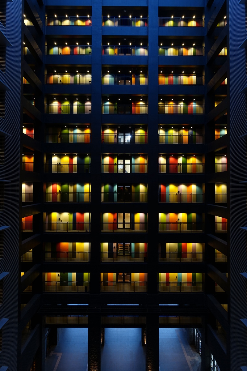 Interior of building atrium with multi-coloured doors on many floors (SOHO Odaiba, Tokyo)