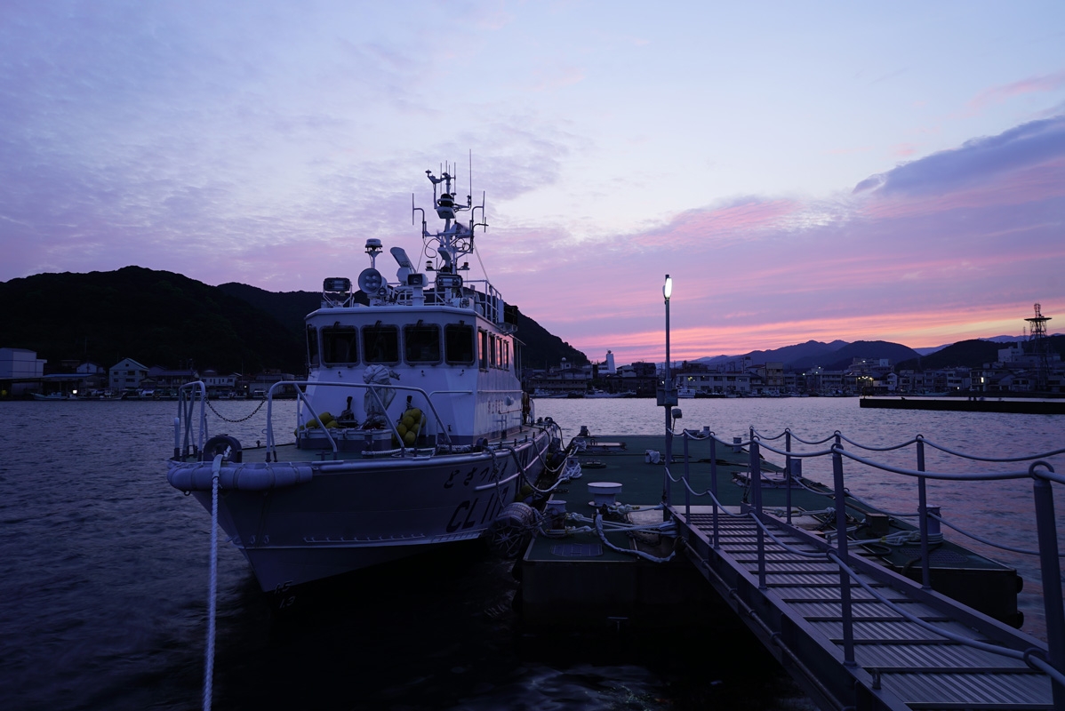 Boat and jetty at dusk with red sky