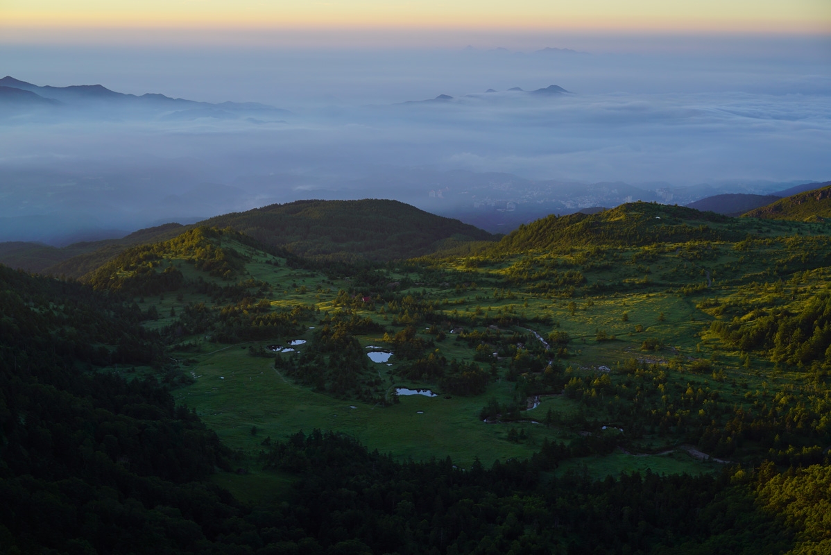 High ground in foreground with low cloud and protruding hilltops in background