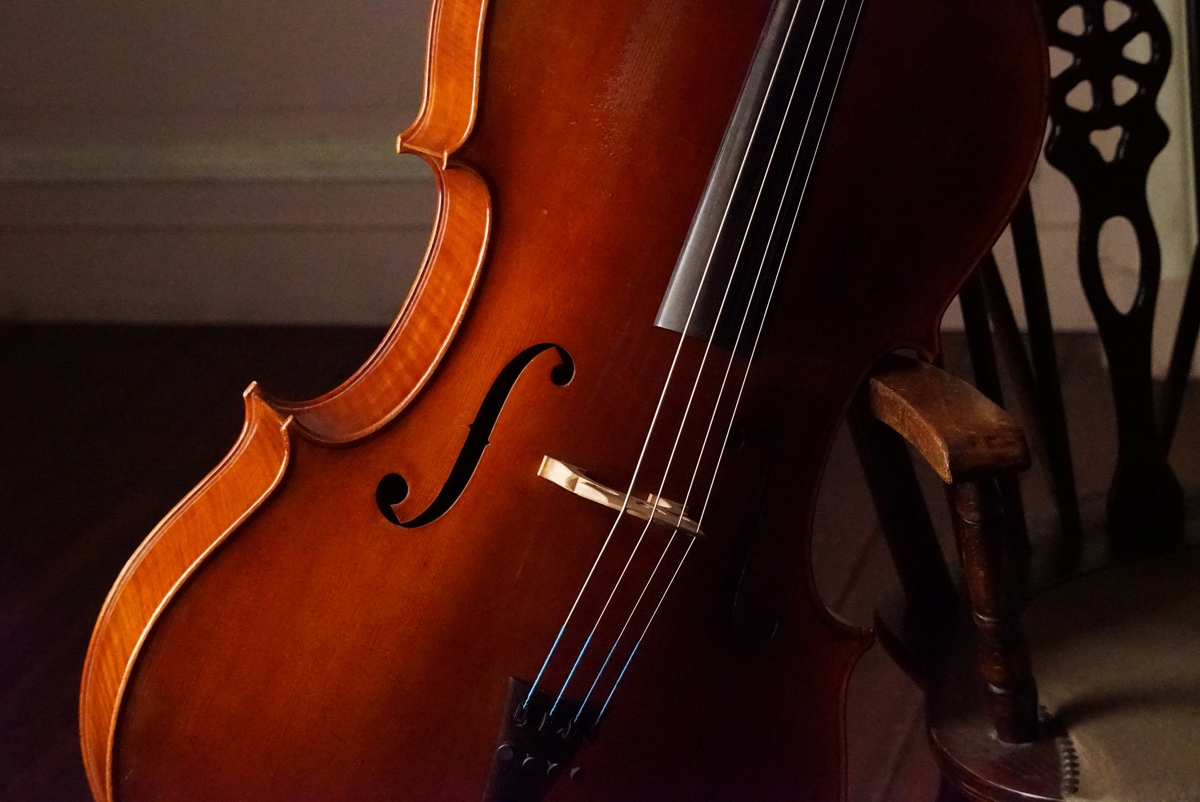 Cello leaning against wooden chair