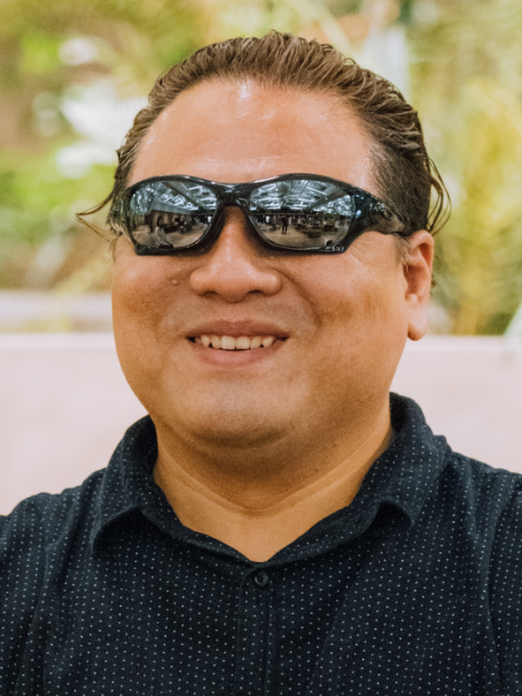 Photo of Hironoti Sato smiling and sitting