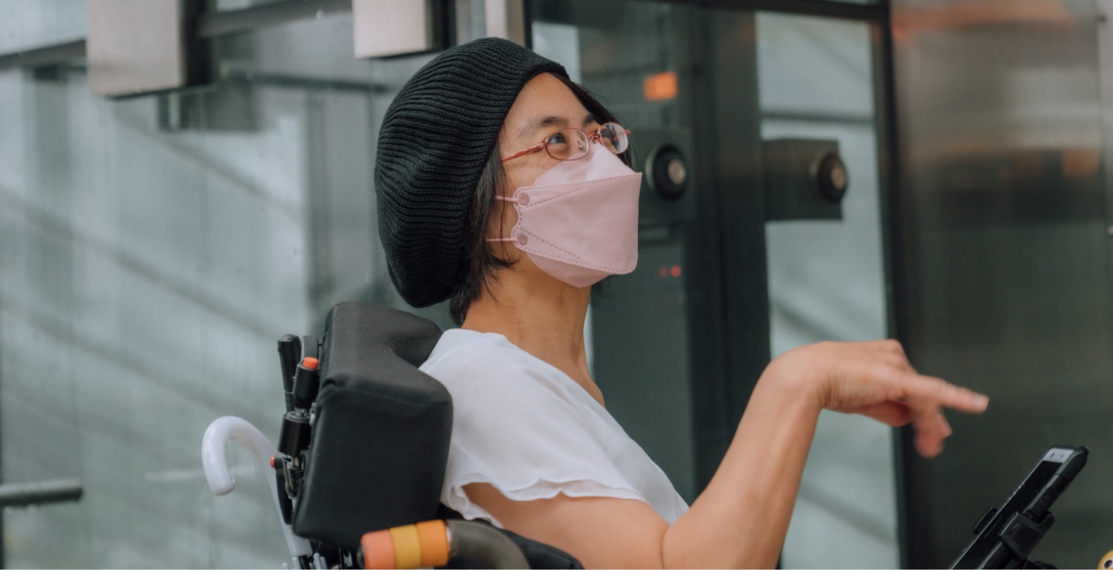 A female on a wheelchair talking in an elevator.