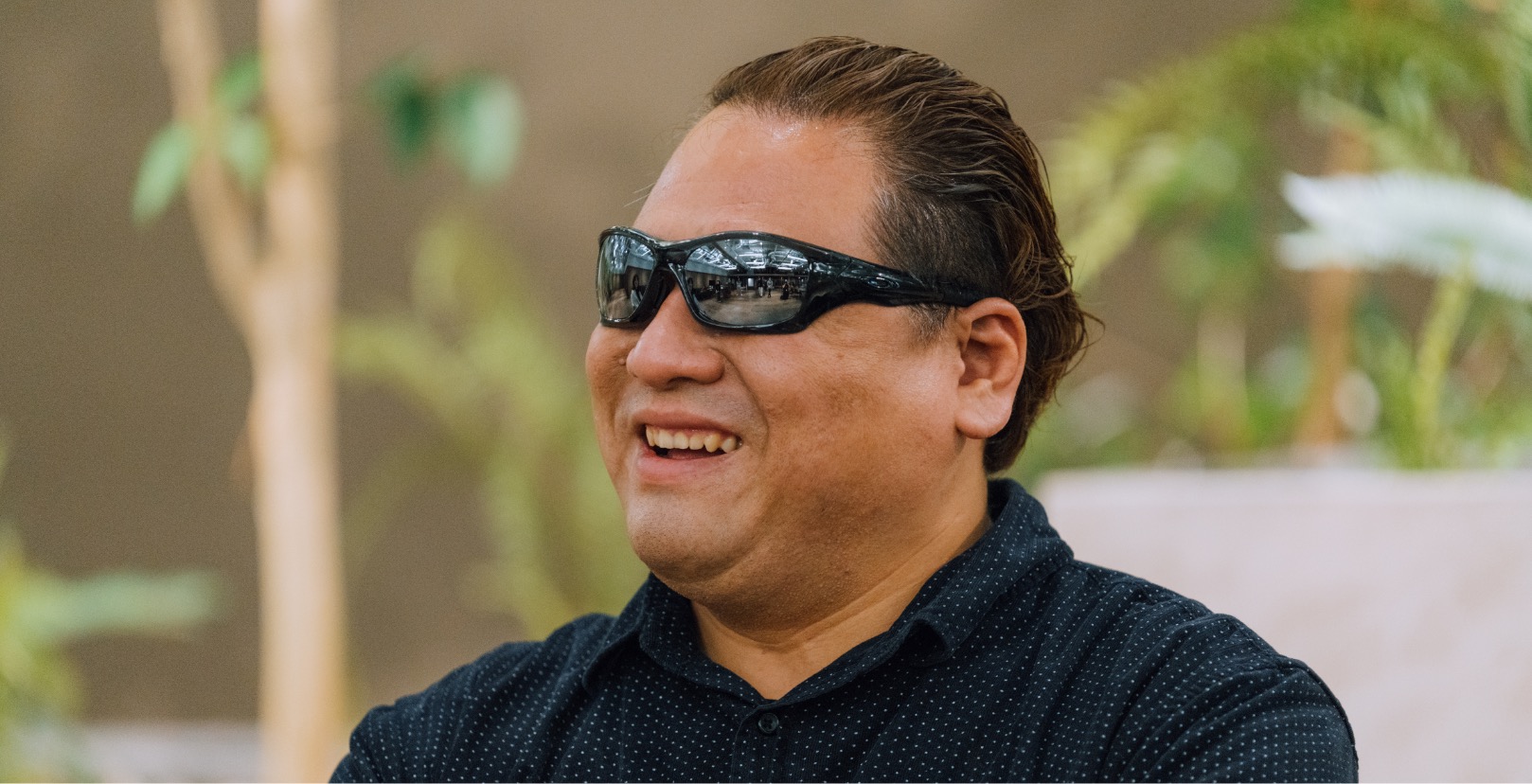 A male with sunglasses talking and smiling