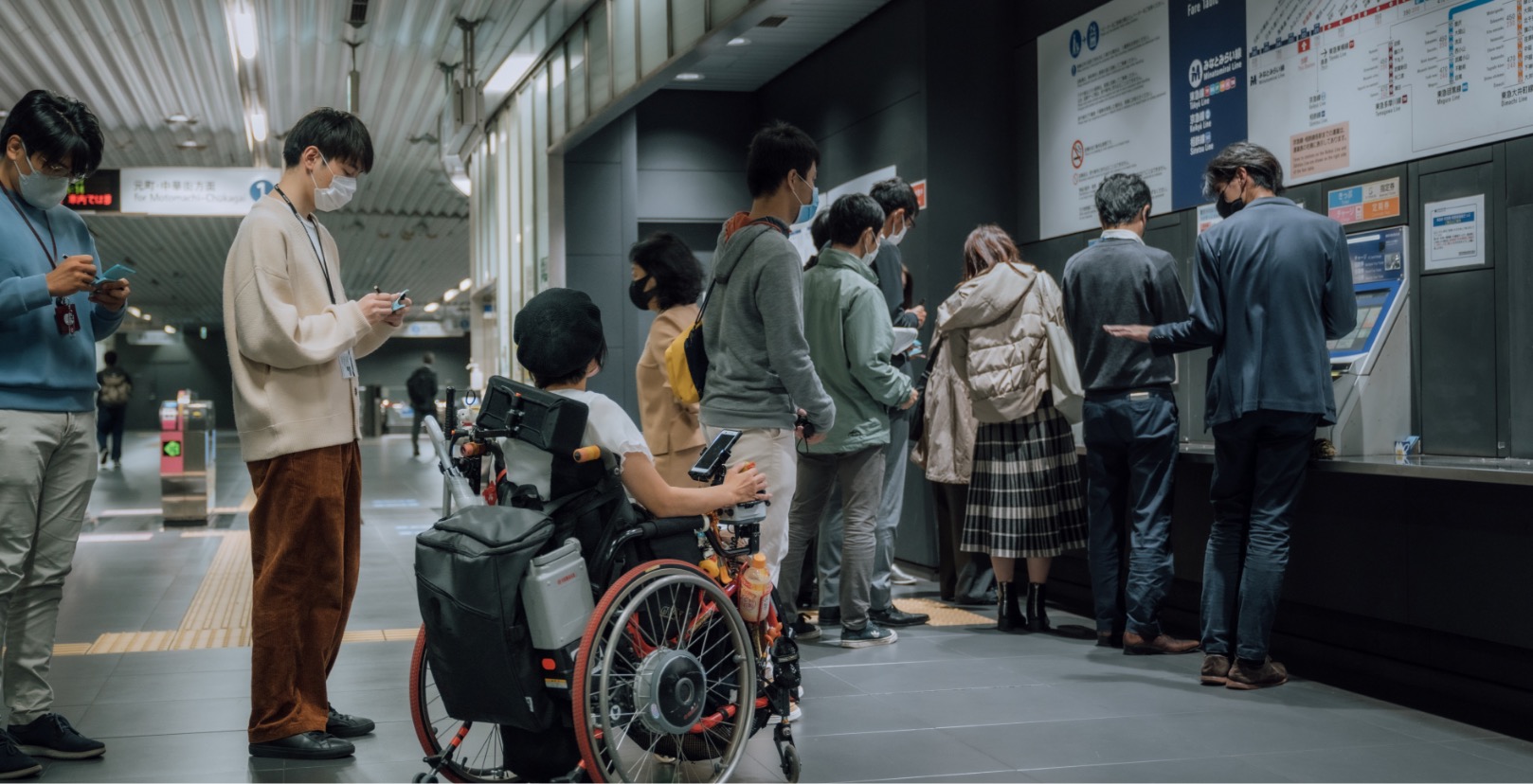 A group of people at a ticketing booth in a train station