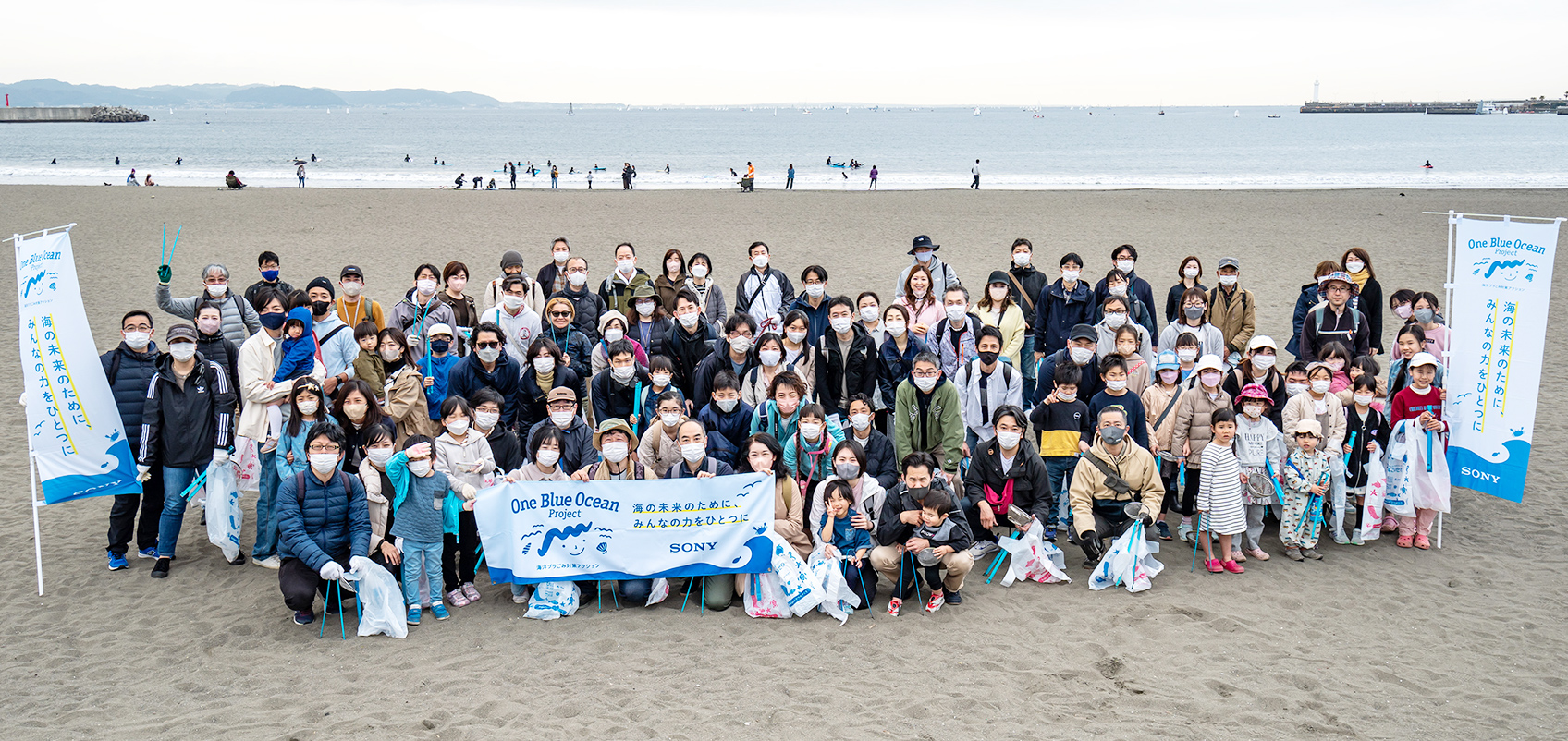 Many participants gathered on the beach with "One Blue Ocean" banners